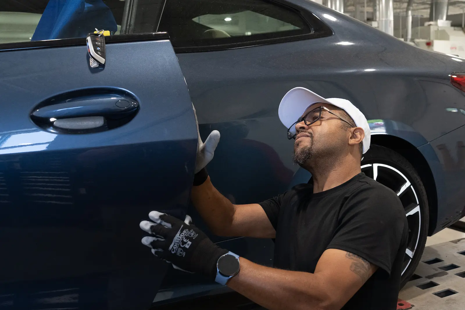 Mechanic standing near vehicles in a modern repair shop